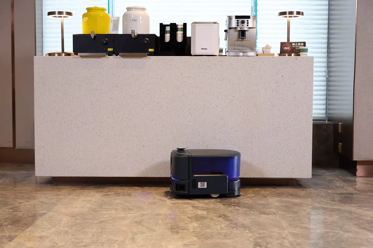 Robot de limpieza Keenon KLEENBOT C20 limpiando junto al mostrador de una cafetería